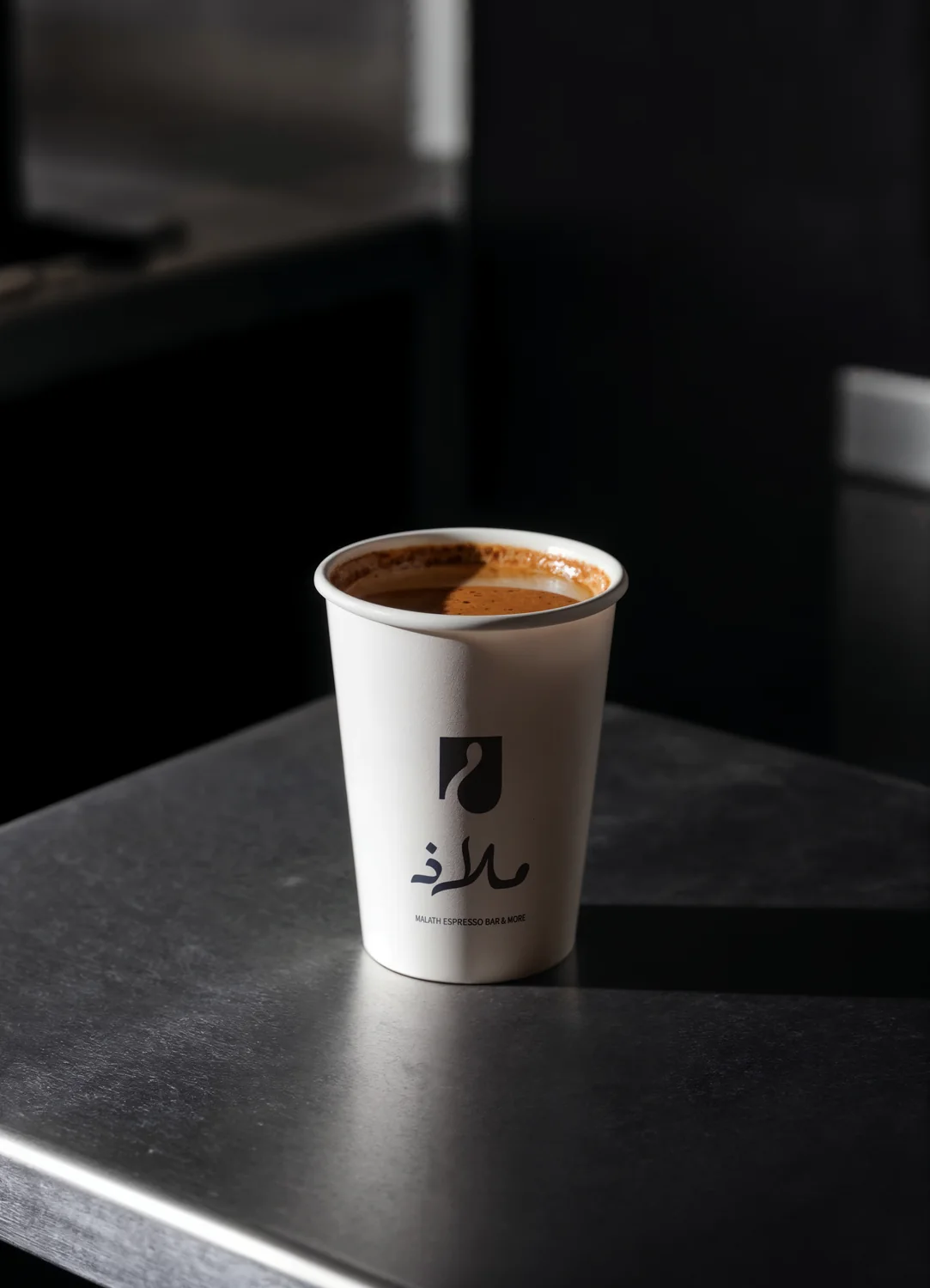 كوب قهوة يحمل شعار ملاذ